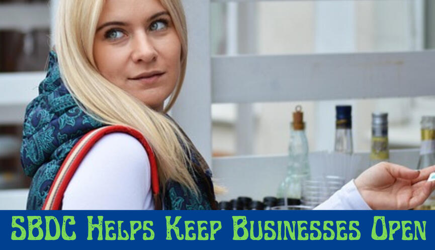 Image of a blonde woman looking over her shoulder with the words SBDC Helps Keep Businesses Open
